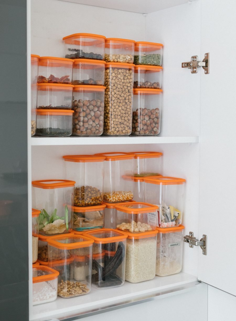 Alacena organizada con recipientes transparentes de tapa naranja